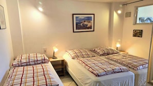A room with two beds, a nightstand, a lamp, and a framed picture on the wall. - Mobile Home im Ferienpark mit Seezugang (Dabel)