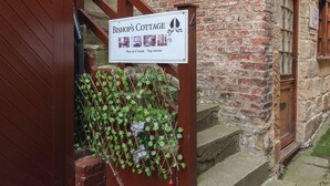 A sign for Bishop's Cottage indicating it sleeps up to 3 people and is dog-friendly. - Bishop's Cottage (Whitby)