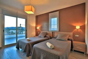 A hotel room with two beds, a balcony, and a large window. - 5 minutes to Ibiza Town | Pool | Spa Pool (Can Ramon)