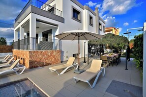 A modern building with a pool area, outdoor seating, and a stone feature. - 5 minutes to Ibiza Town | Pool | Spa Pool (Can Ramon)