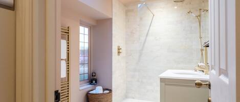 Une salle de bain moderne avec une douche, un lavabo et une fenêtre.