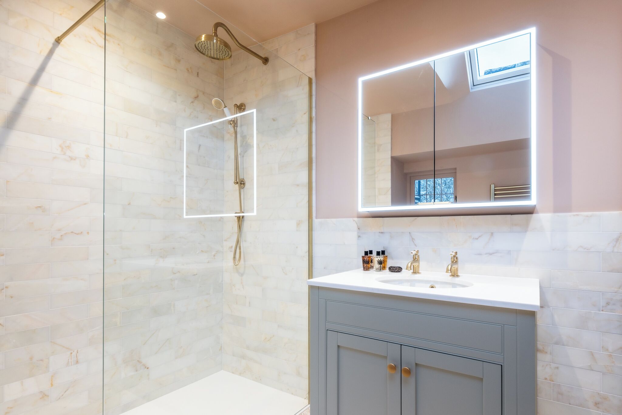 A modern bathroom with a glass-enclosed shower, a vanity with a mirror, and a sink.