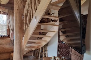 A wooden staircase with a rustic design, a fireplace, and a television mounted on the wall. - Comfortable Apartment Very Close to the Beach (gmina Będzino)