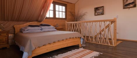 Un dormitorio con cama de madera, una ventana, baranda de madera y alfombra.