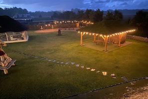 A well-maintained lawn with a stone pathway leading to a wooden gazebo. - Comfortable Apartment Very Close to the Beach (gmina Będzino)