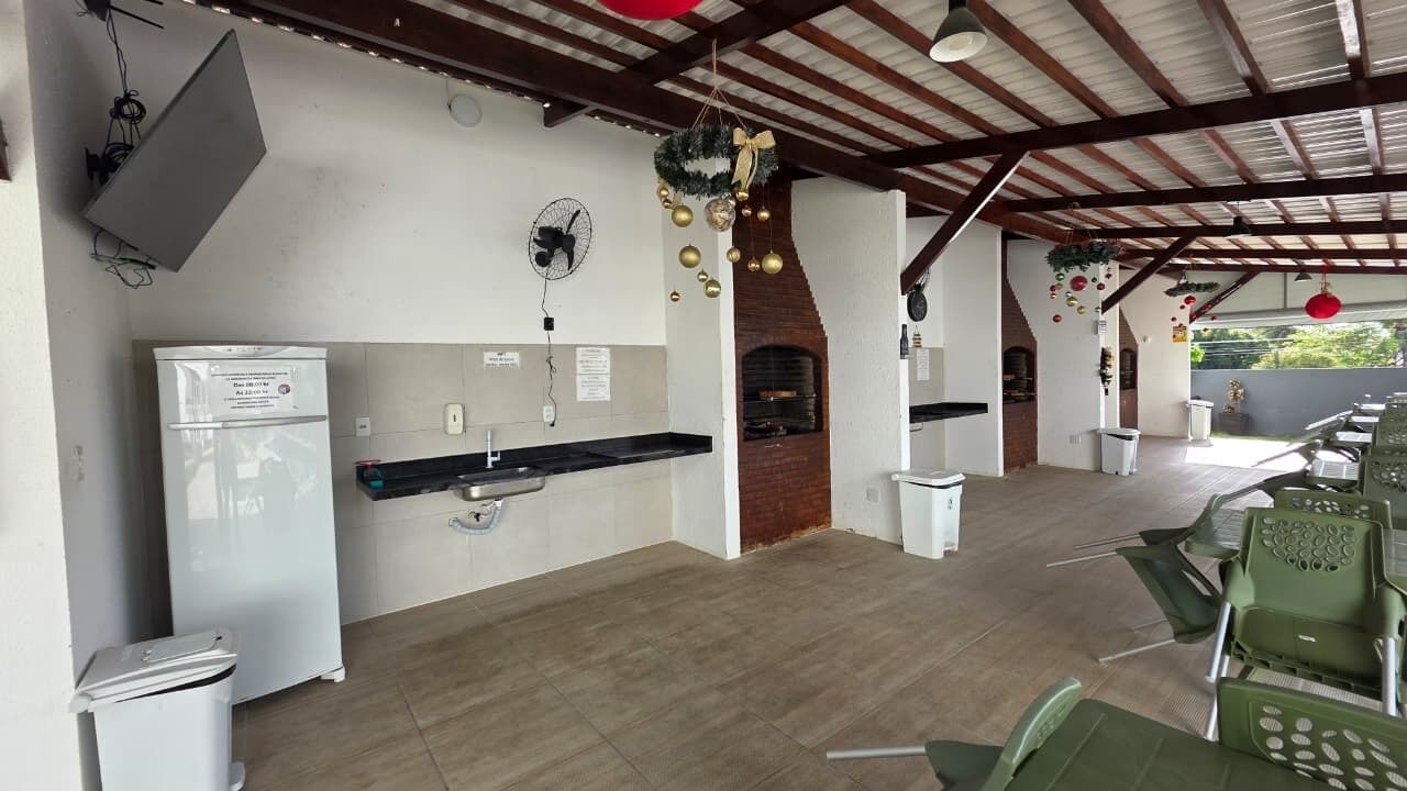 An outdoor kitchen area with a refrigerator, sink, and a brick oven.