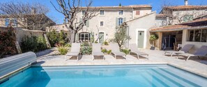 A swimming pool with lounge chairs and a stone building with a tiled roof. - Le Petit Citronnier - Four Bedroom Villa, Sleeps 8 (Maillane)