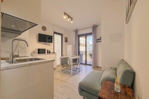 A compact living space with a kitchenette, dining area, and a sofa. - Comfort, Style and Connectivity Included (Civitanova Marche)