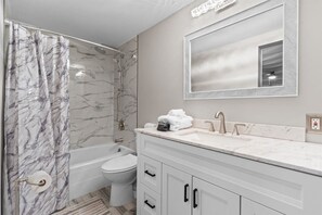 Une salle de bain équipée d’une douche, de toilettes et d’un meuble-lavabo avec un miroir.