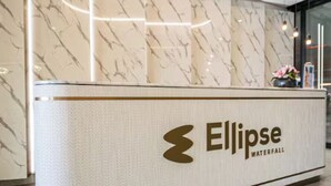 Ein Empfangsschalter mit Marmorwand und dem Logo 'Ellipse Waterfall'.