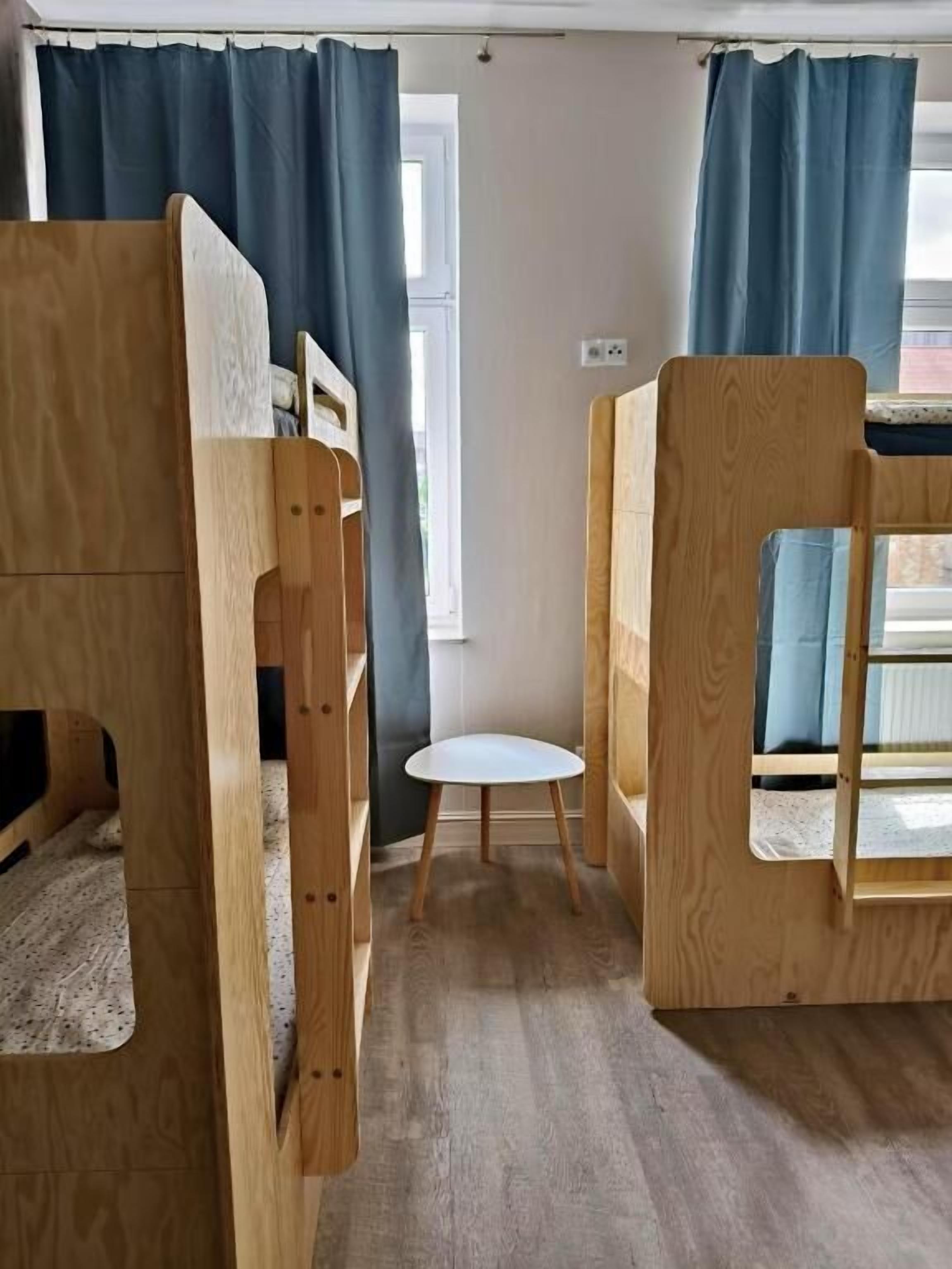 Une chambre avec des lits superposés et une petite table.