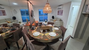 A dining area with a round table set for four, surrounded by chairs. - Novo Torres do Porto 202B by La Playa  (Ipojuca)