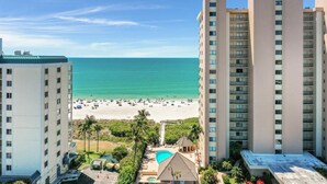 A high-rise hotel with a view of the beach and a pool area. - Sea Winds 1404 (Marco Island)