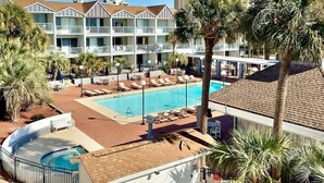 Ein Hotel mit Pool, Palmen und blauem Himmel.