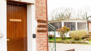 Un mur de briques sur lequel sont fixées des panneaux en bois indiquant « Appartement », « Chambre 3 » et « Ranch ».