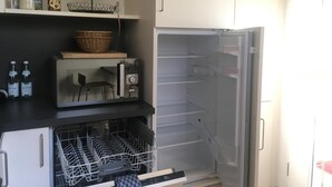 Eine Küche mit Mikrowelle, Kühlschrank und Geschirrspüler.