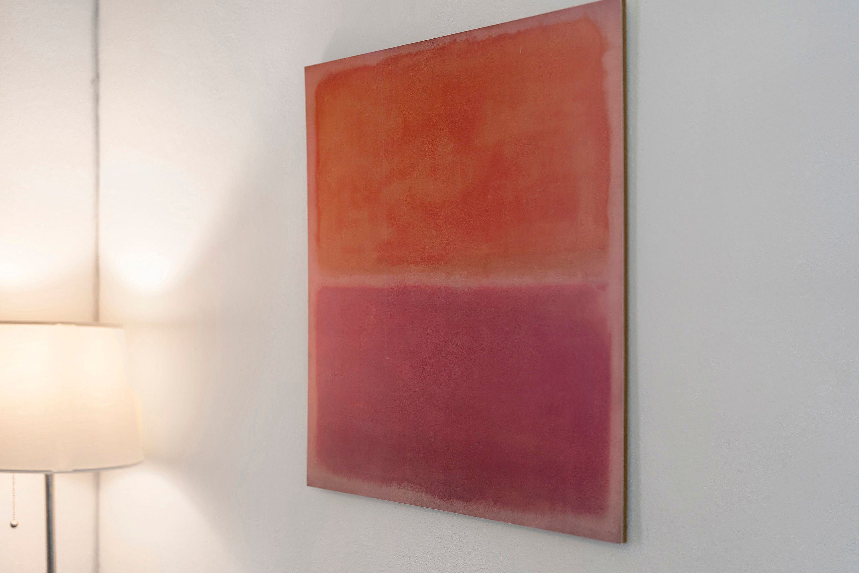A wall with a large, rectangular artwork.