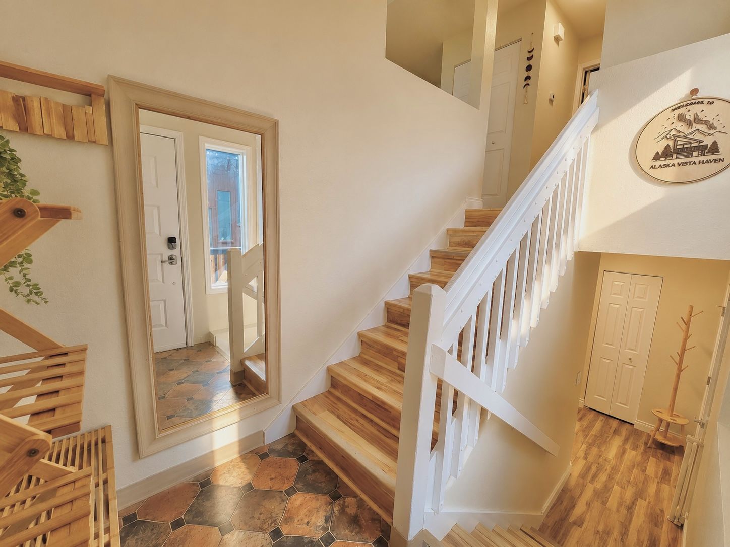 Un escalier avec des marches en bois et des rampes blanches, menant à un deuxième étage.