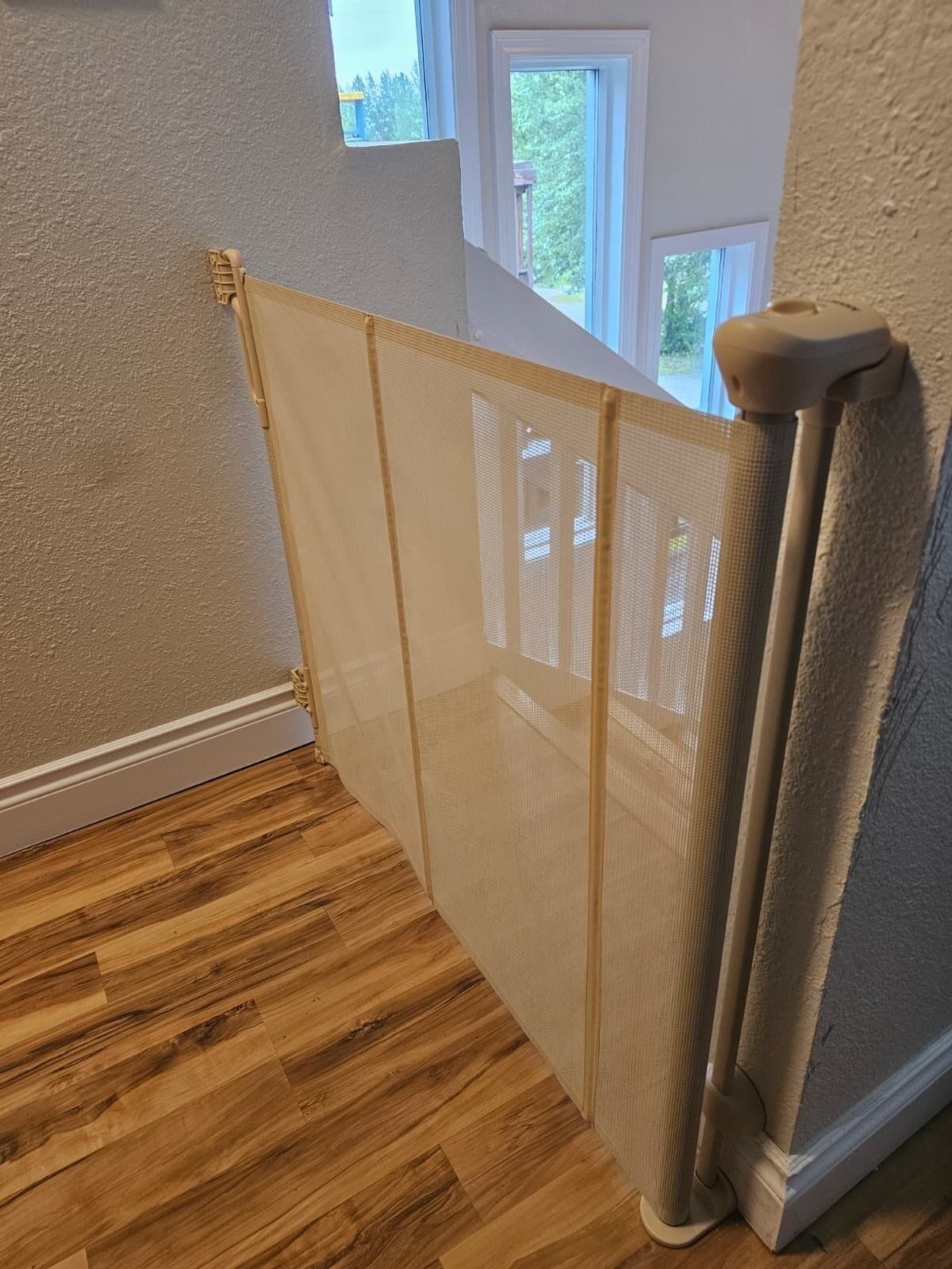 A room with a wooden floor, a white wall, and a window.