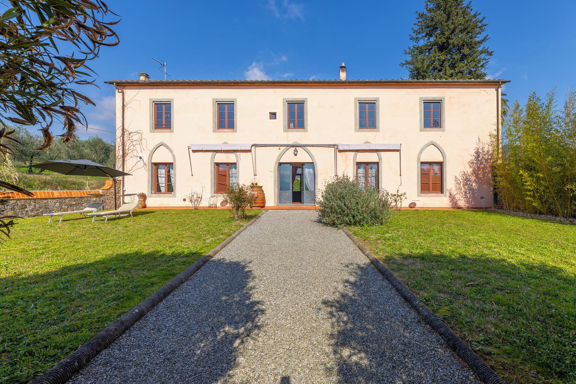 Un bâtiment à deux étages doté d’une entrée centrale, d’une allée gravillonnée et d’une pelouse bien entretenue.