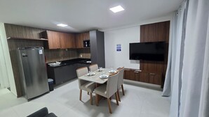 Eine moderne Küche mit Essbereich, integriertem Fernseher und Kühlschrank.