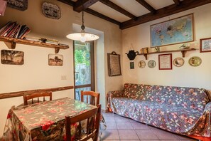 Une pièce chaleureuse avec une table en bois, un canapé à motifs floraux et une carte accrochée au mur.