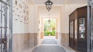 A hallway with a star-patterned floor, a wooden cabinet, and a view of a garden. - Marmorata 169 - Loft in Testaccio (Rome)