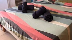 Een hotelkamer met een bed, een kledingkast en een gordijn.