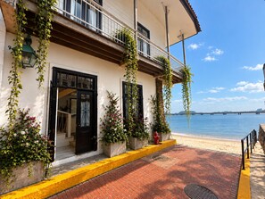 Un edificio costero con balcón, vista a la playa y cielo despejado.