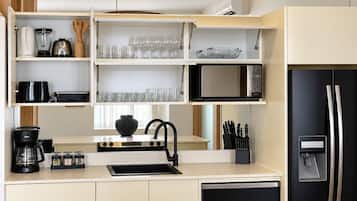 A modern kitchen with a built-in stove, a black refrigerator, and a microwave.