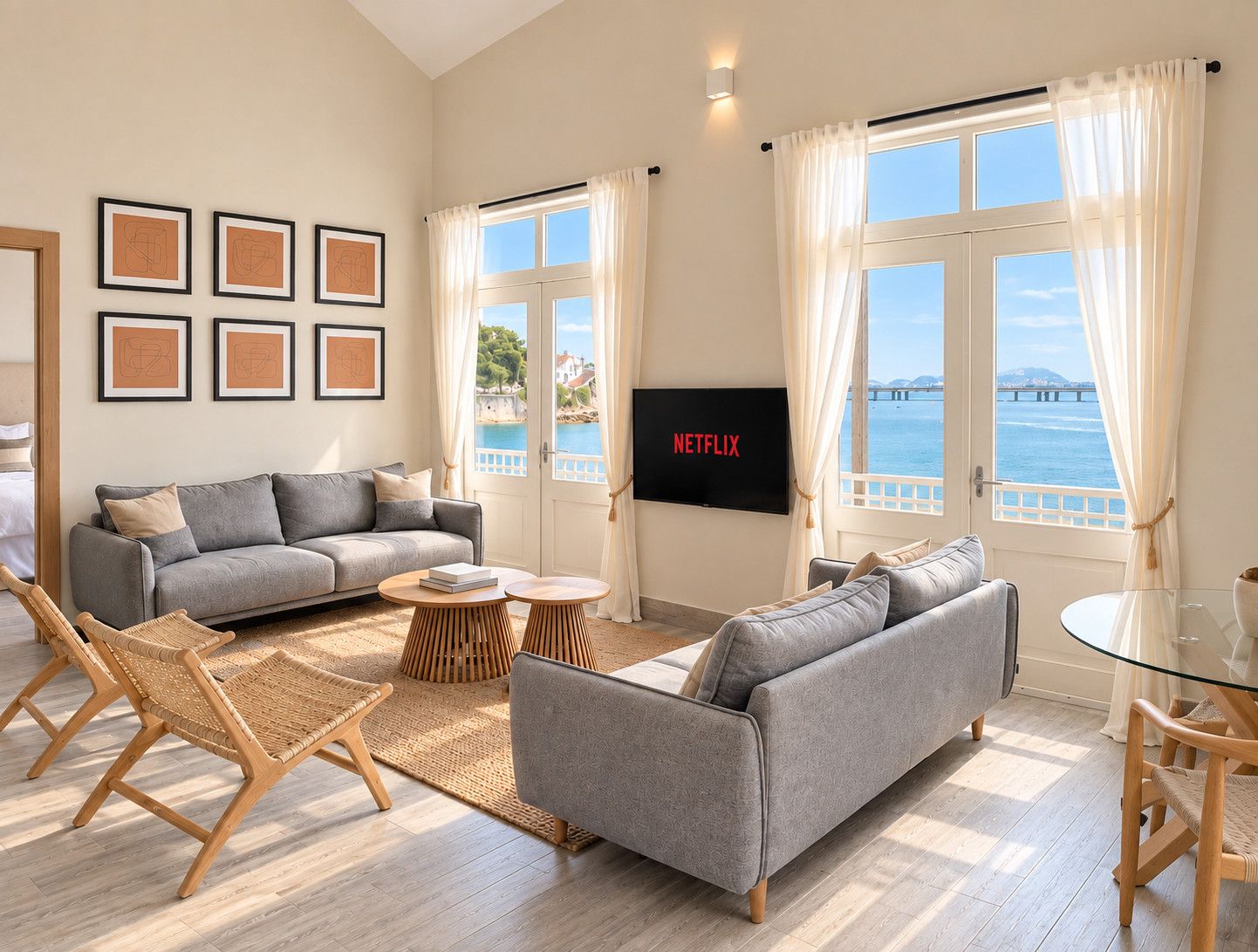 A modern living room with a grey sofa, a coffee table, wicker chairs, and a TV screen displaying 'NETFLIX'.