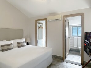 A hotel room with a large bed, a bedside table with a lamp, a wardrobe, and a view of the bathroom. - Unique house with direct access to the beach, four bedrooms, balcony and design (Ciudad de Panamá)