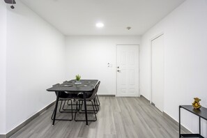 Ein Zimmer mit einem schwarzen Tisch, weißen Wänden und einem grauen Boden.