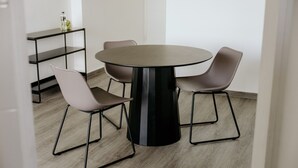 A round table with four chairs, a black metal base, and a wooden floor. - Modern with terrace 2BR in Panama City 10B (Ciudad de Panamá)