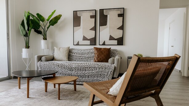 A living room with a sofa, a coffee table, a chair, two potted plants, and abstract wall art. - Modern with terrace 2BR in Panama City 10B (Ciudad de Panamá)