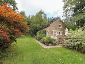 A stone cottage with a grassy yard and a small garden area. - Pigwig Cottage (Matlock)