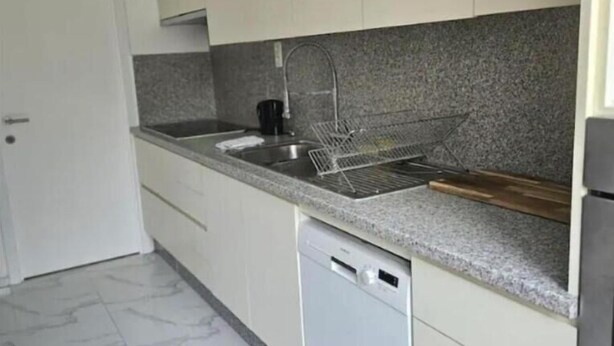 A kitchen with white cabinets, a granite countertop, a dishwasher, and a stainless steel sink. - Chambre Lit double (Dunkirk)