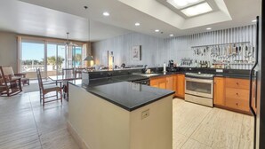 Una cocina moderna con una isla central, armarios de madera y vistas al exterior.