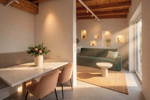 Ein modernes Interieur mit Essbereich, einem grĂŒnen Sofa und Wandleuchten.