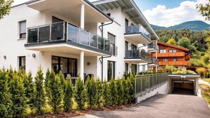 A modern multi-story building with balconies, a driveway, and a mountain backdrop. - ZWEITE HEIMAT – Cozy Apartment with Garden (Fügen)