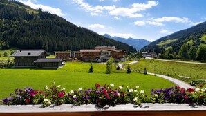 A residential area with houses, a road, and a mountain backdrop. - BEIM LOIS Dorfblick – 2 Floors & Sauna Access (Gerlos)