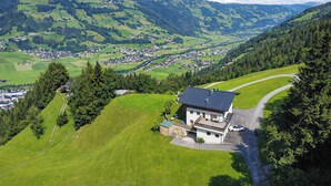 A modern house with a large balcony, surrounded by lush green fields and mountains. - HOCHEBEN – Balcony & Private Sauna (Ramsau im Zillertal)