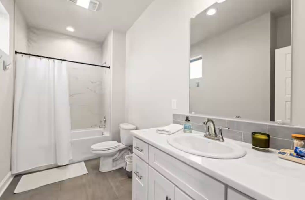 A modern bathroom with a bathtub, toilet, and sink.