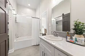 Une salle de bain moderne avec une baignoire, un lavabo et un miroir.