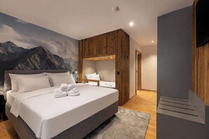 Une chambre moderne avec un grand lit, un lambris en bois et une fresque représentant une montagne sur le mur.
