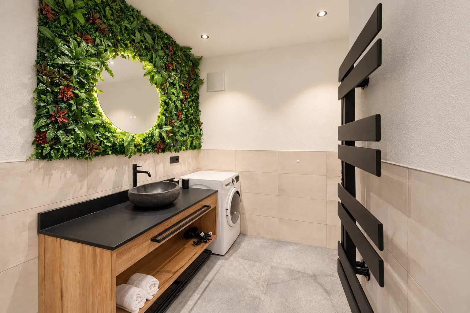 Un baño moderno con lavamanos integrado, un espejo, lavadora y un perchero para toallas.