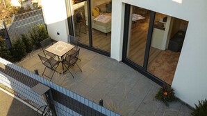 A modern house with a patio, a dining area, and a living room with large glass doors. - ROFANLODGE Gutschlhofer – A house with a view, a terrace and parking (Mariatal)