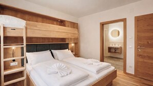 Ein Hotelzimmer mit Etagenbett, Nachttisch, Spiegel und Holzschrank.