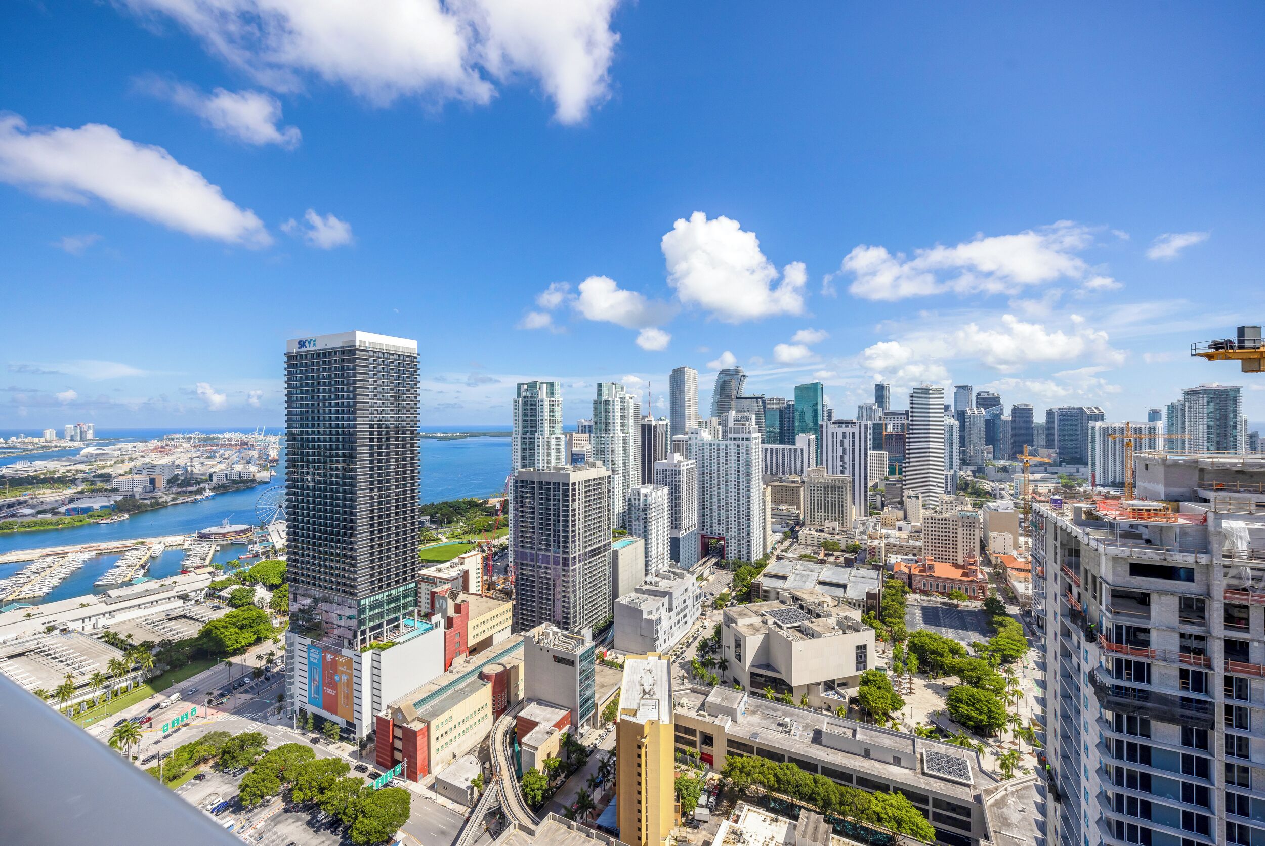 A cityscape with high-rise buildings, a marina, and a clear sky.