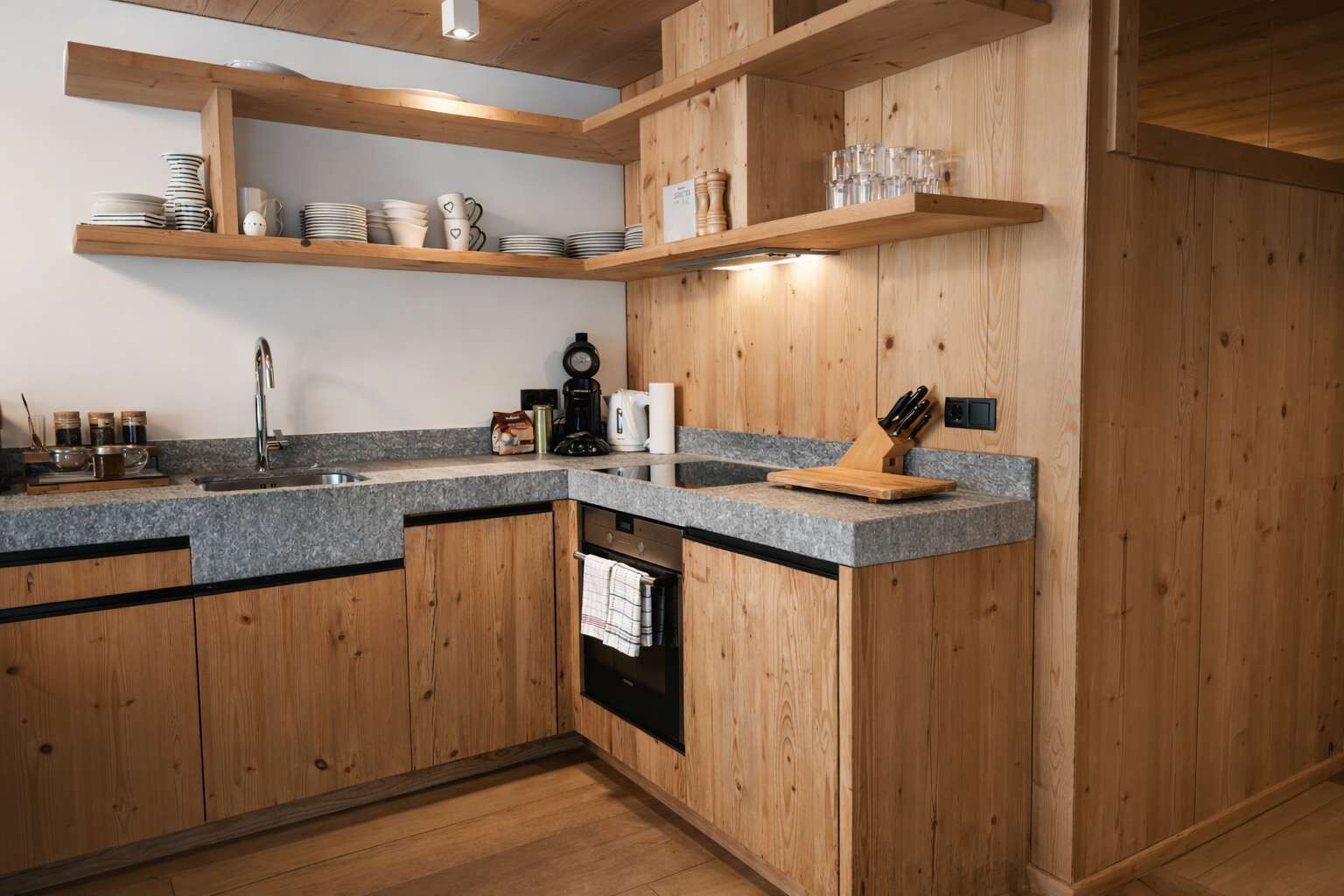 Une cuisine dotée de meubles en bois, de plans de travail en granit et d’un lave-vaisselle encastré.
